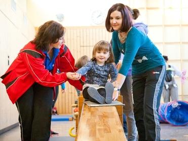 Kind bewegt sich auf einer Langbank